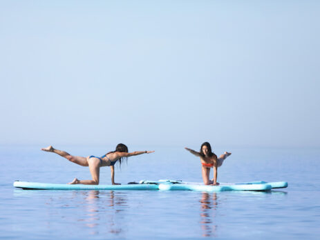 2 dames doen een yoga oefening op sup veerse meer